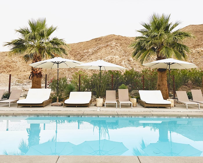 e-mens-C1sGutffT_4-unsplash-downsized Apartment community resort-style pool with lounge chairs